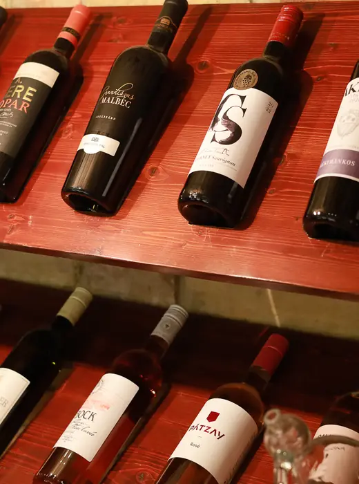 Hungarian wine bottles on wooden cellar shelves
